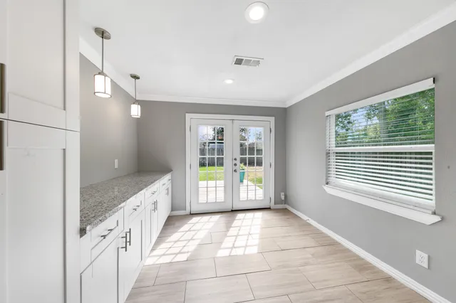 a bathroom with a granite countertop sink a large mirror and a bathtub next to a window