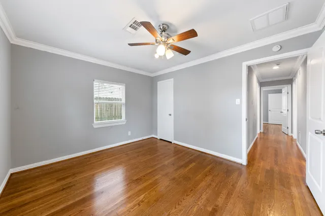 a view of a big room with wooden floor and windows