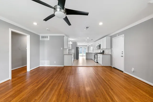 a view of empty room with wooden floor