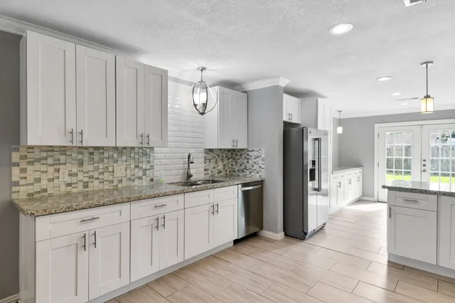 a kitchen with stainless steel appliances granite countertop a refrigerator and a sink