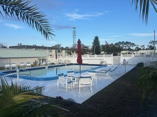 a swimming pool with outdoor seating and lake view