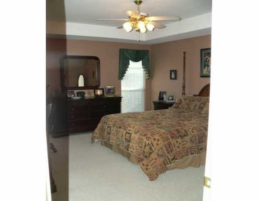 5113 Cavendish Drive Corpus Christi, TX 78413 - Photo 5 of 7 a bedroom with a bed and a chandelier
