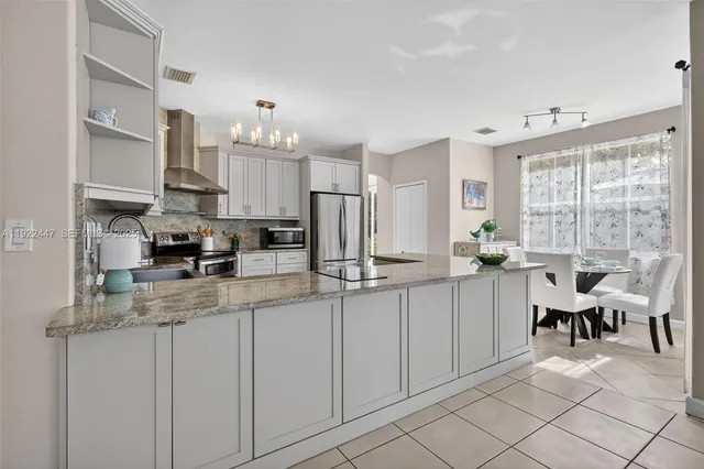 a kitchen with white cabinets and sink