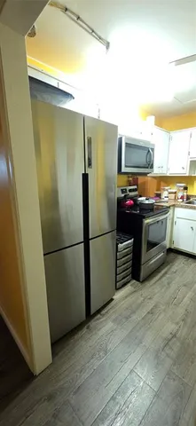 a kitchen with stainless steel appliances a refrigerator a stove a sink and a refrigerator