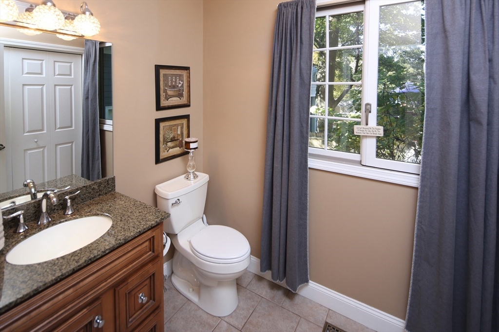 40 Lazel Street Whitman, MA 02382 - Photo 16 of 20 a bathroom with a granite countertop toilet a sink and a mirror