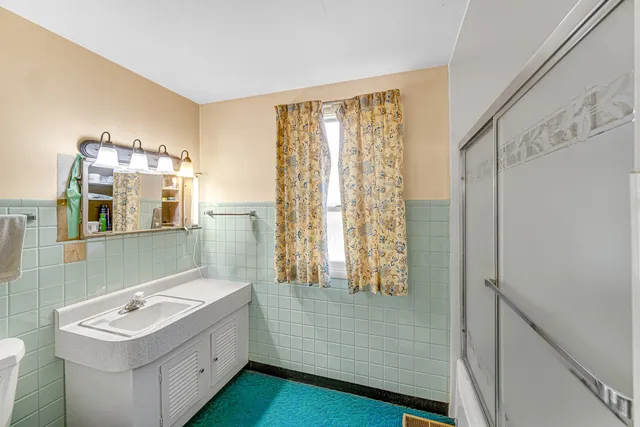 a bathroom with a sink mirror and a bathtub