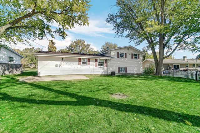 a view of a house with a big yard and large trees