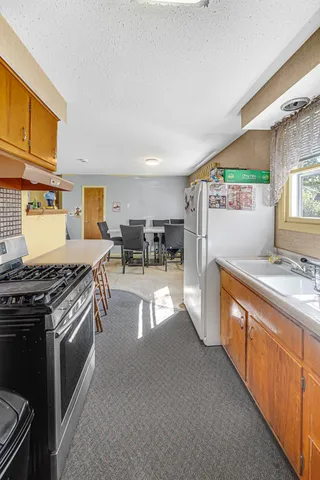 a kitchen with stainless steel appliances granite countertop a stove a sink and a refrigerator