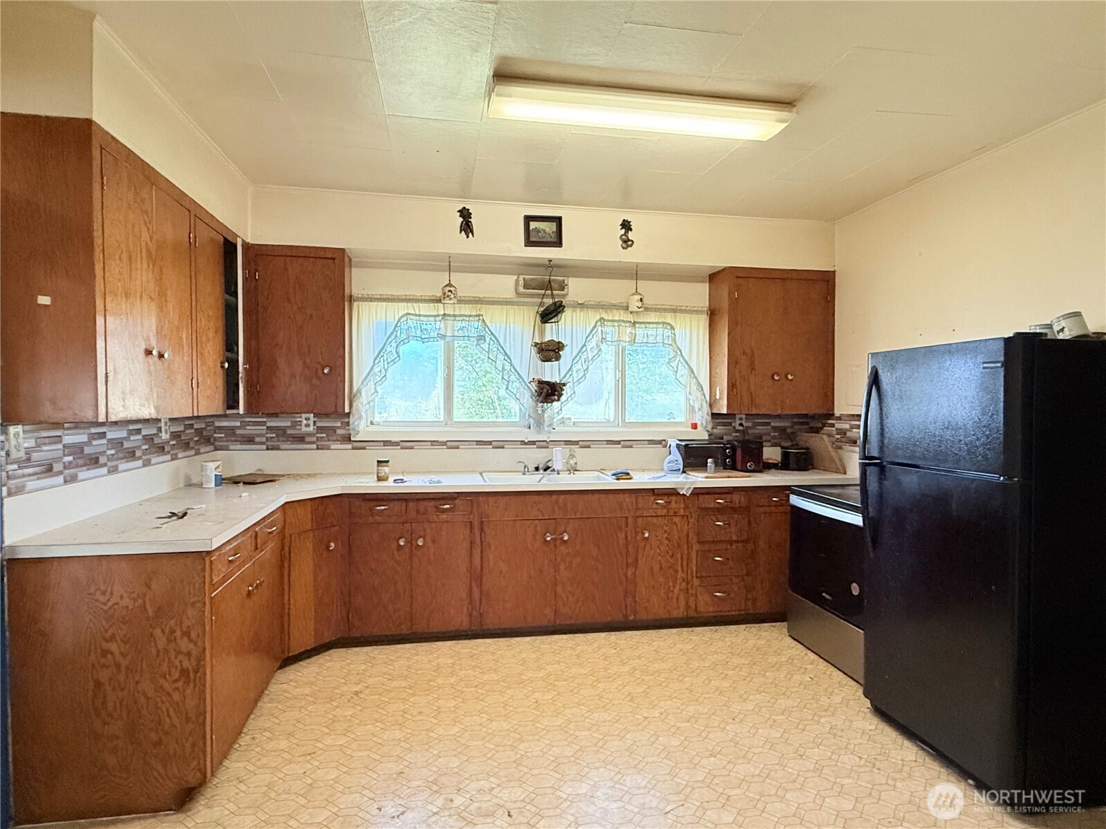 150 Southwest South 1st Creston, WA 99117 - Photo 4 of 22 a large kitchen with stainless steel appliances kitchen island granite countertop a sink and dishwasher a refrigerator with wooden cabinets