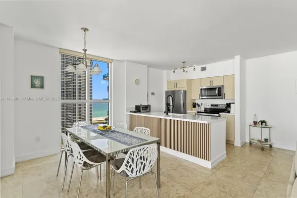 a kitchen with stainless steel appliances granite countertop a stove top oven a sink dishwasher and a refrigerator with wooden floor