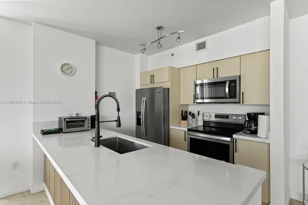 a kitchen with stainless steel appliances a microwave sink and refrigerator