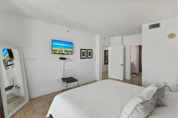 a bedroom with a bed and a flat screen tv