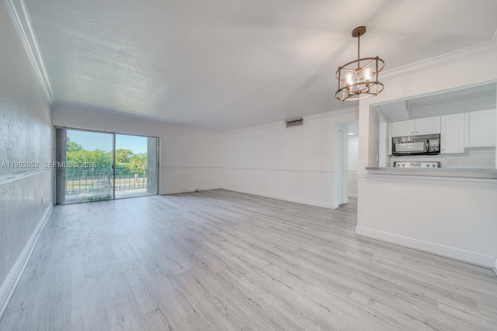 9459 Southwest 76th Street, Unit R5 Miami, FL 33173 - Photo 5 of 33 wooden floor in an empty room with a window