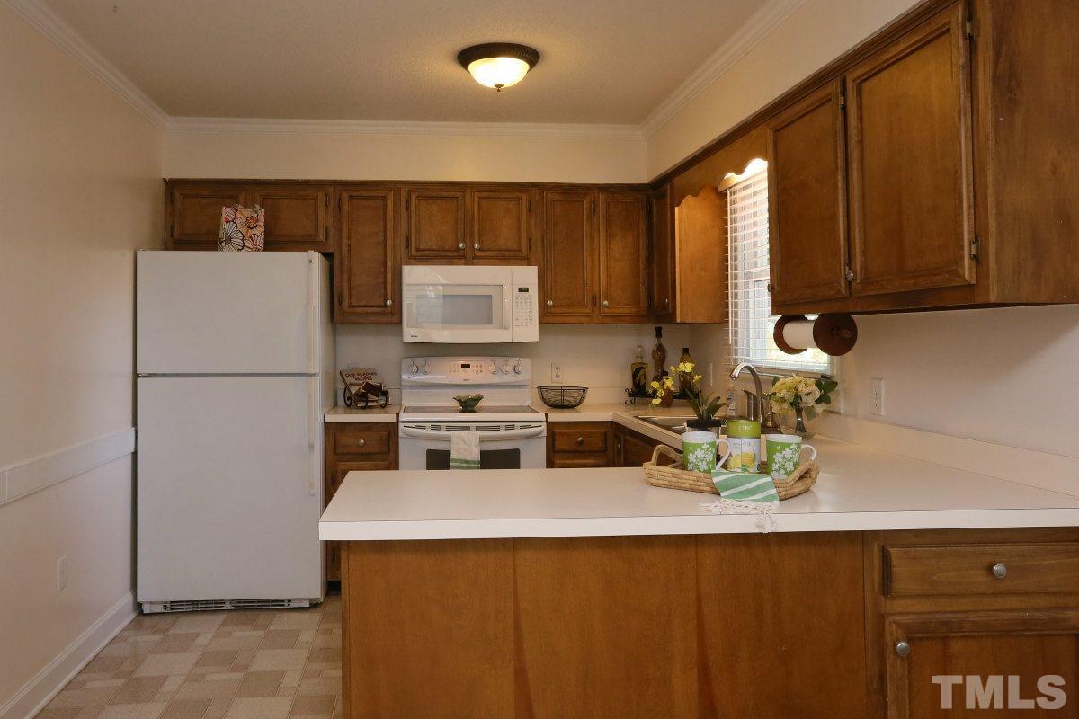 3809 Old Coach Road Raleigh, NC 27616 - Photo 8 of 25 a kitchen with a sink a refrigerator and cabinets