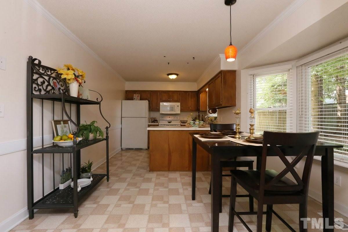 3809 Old Coach Road Raleigh, NC 27616 - Photo 9 of 25 a kitchen with a dining table chairs sink and cabinets