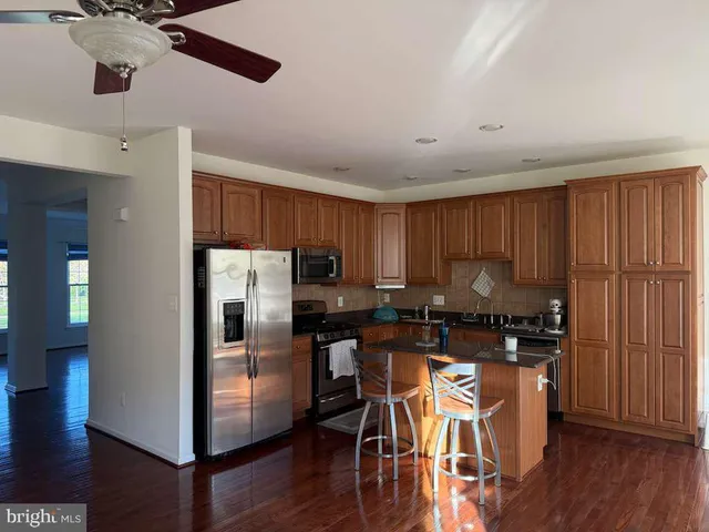 a kitchen with stainless steel appliances granite countertop a refrigerator a stove top oven a sink and dishwasher