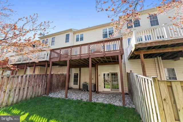 a view of a house with a yard and wooden deck