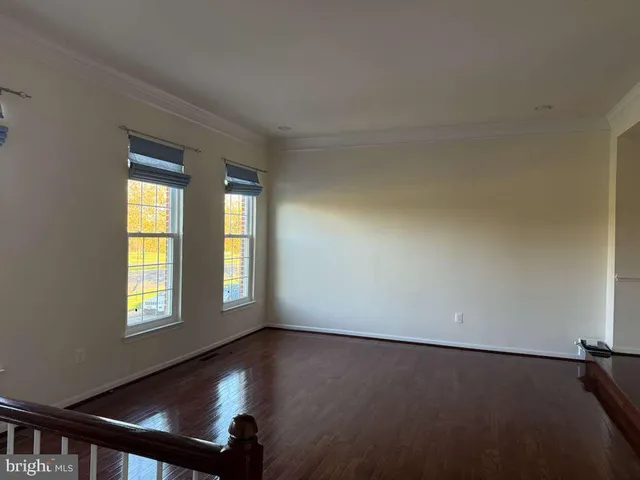 a view of a room with wooden floor and windows