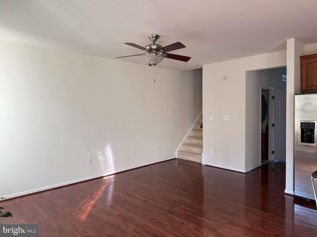 25210 Whippoorwill Terrace Chantilly, VA 20152 - Photo 10 of 33 an empty room with wooden floor a ceiling fan and windows
