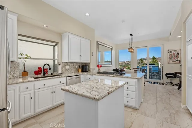 a kitchen with granite countertop a sink cabinets and window