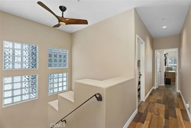 a view of hallway with windows and wooden floor