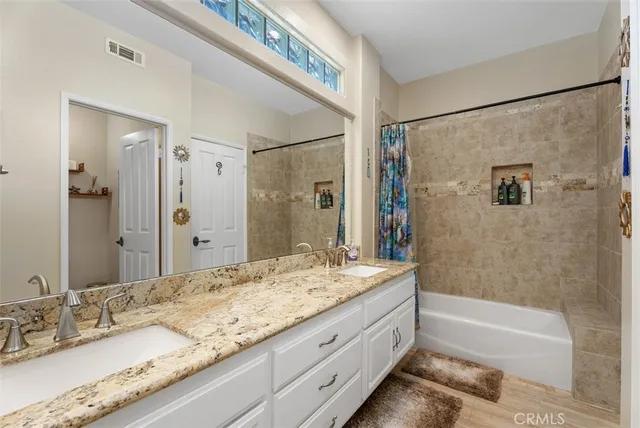 a bathroom with a granite countertop tub shower sink and mirror