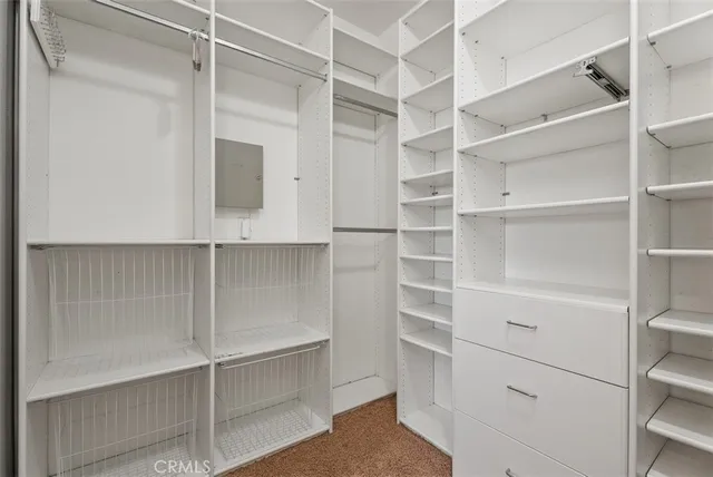 a view of walk in closet with empty racks