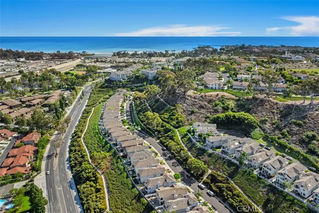 an aerial view of a residential houses with city and ocean view