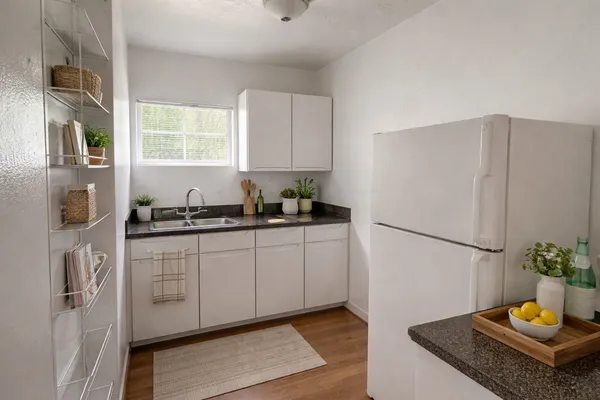 a kitchen with stainless steel appliances granite countertop a refrigerator sink and white cabinets