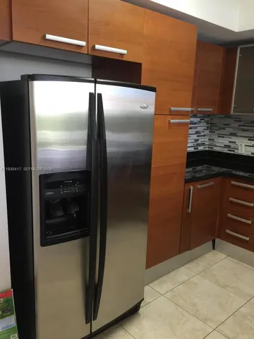 a kitchen with a refrigerator and a sink