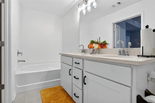 a bathroom with a tub sink vanity and mirror
