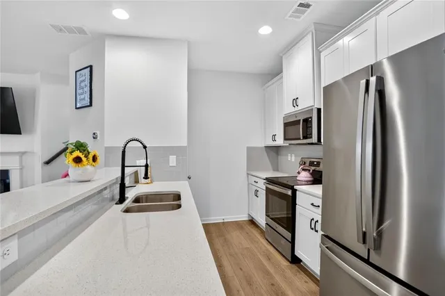 a kitchen with stainless steel appliances a refrigerator sink and stove