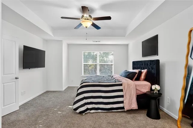 a bedroom with a bed tv and a window