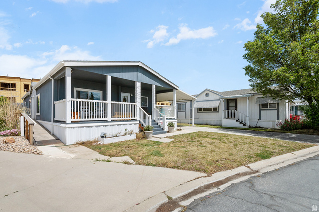 150 West 7500th South, Unit 13 Midvale, UT 84047 - Photo 29 of 32 Exterior siding with a covered porch featuring white railing, an accessible ramp, and a carport