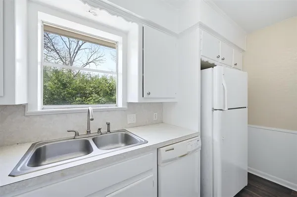 a view white a sink and refrigerator with window