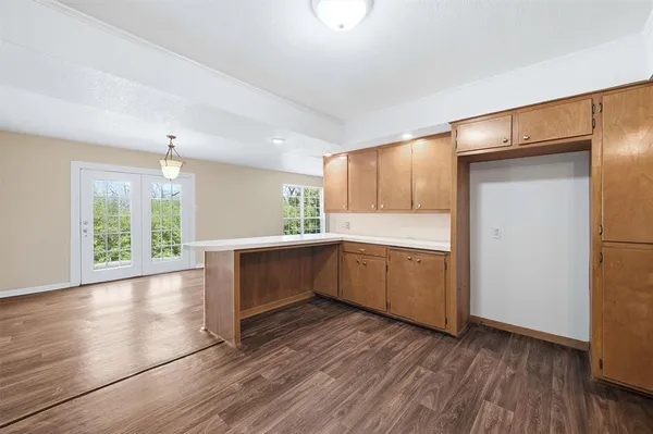 a kitchen with a wooden floor and a window