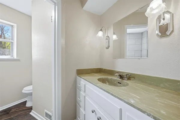 a bathroom with a granite countertop sink and a mirror