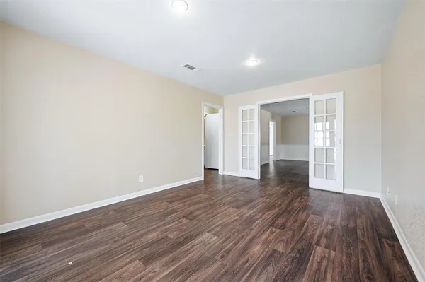 a view of empty room with wooden floor