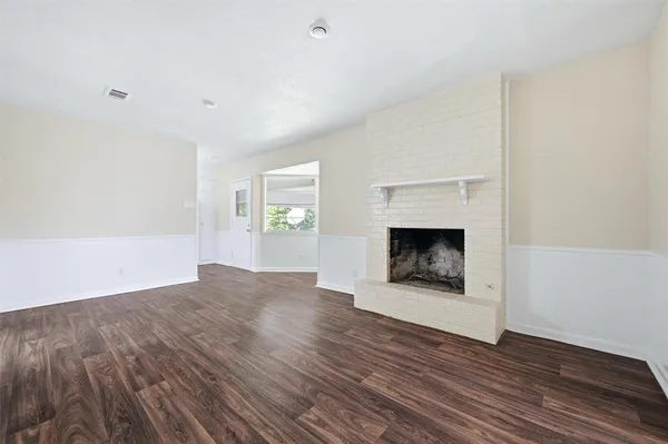 a view of an empty room with a window and fireplace