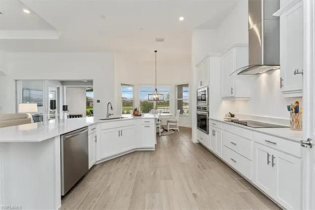 a large white kitchen with cabinets a sink and appliances