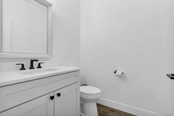 a bathroom with a granite countertop toilet sink and mirror