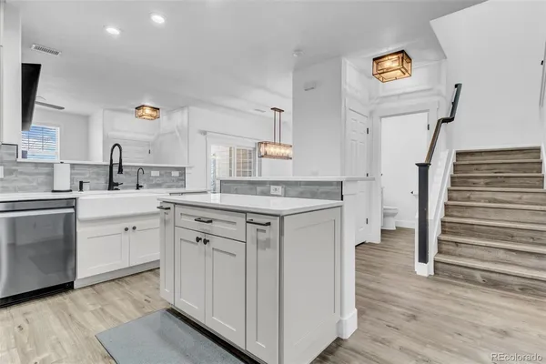 a kitchen with cabinets appliances and a wooden floor