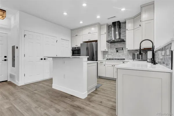 a kitchen with white cabinets and refrigerator