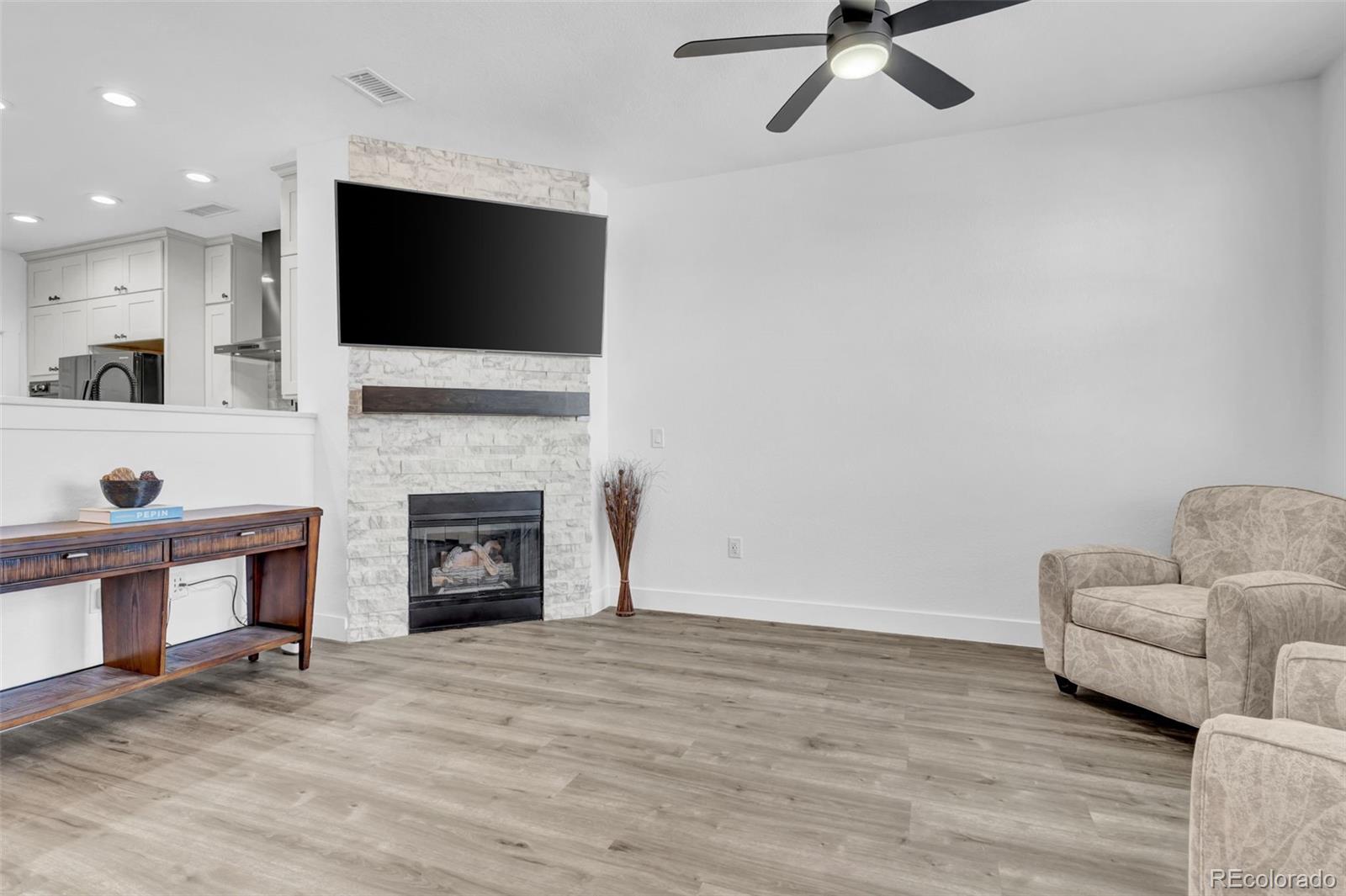 3672 South Perth Circle, Unit 105 Aurora, CO 80013 - Photo 5 of 19 a living room with furniture a flat screen tv and a fireplace