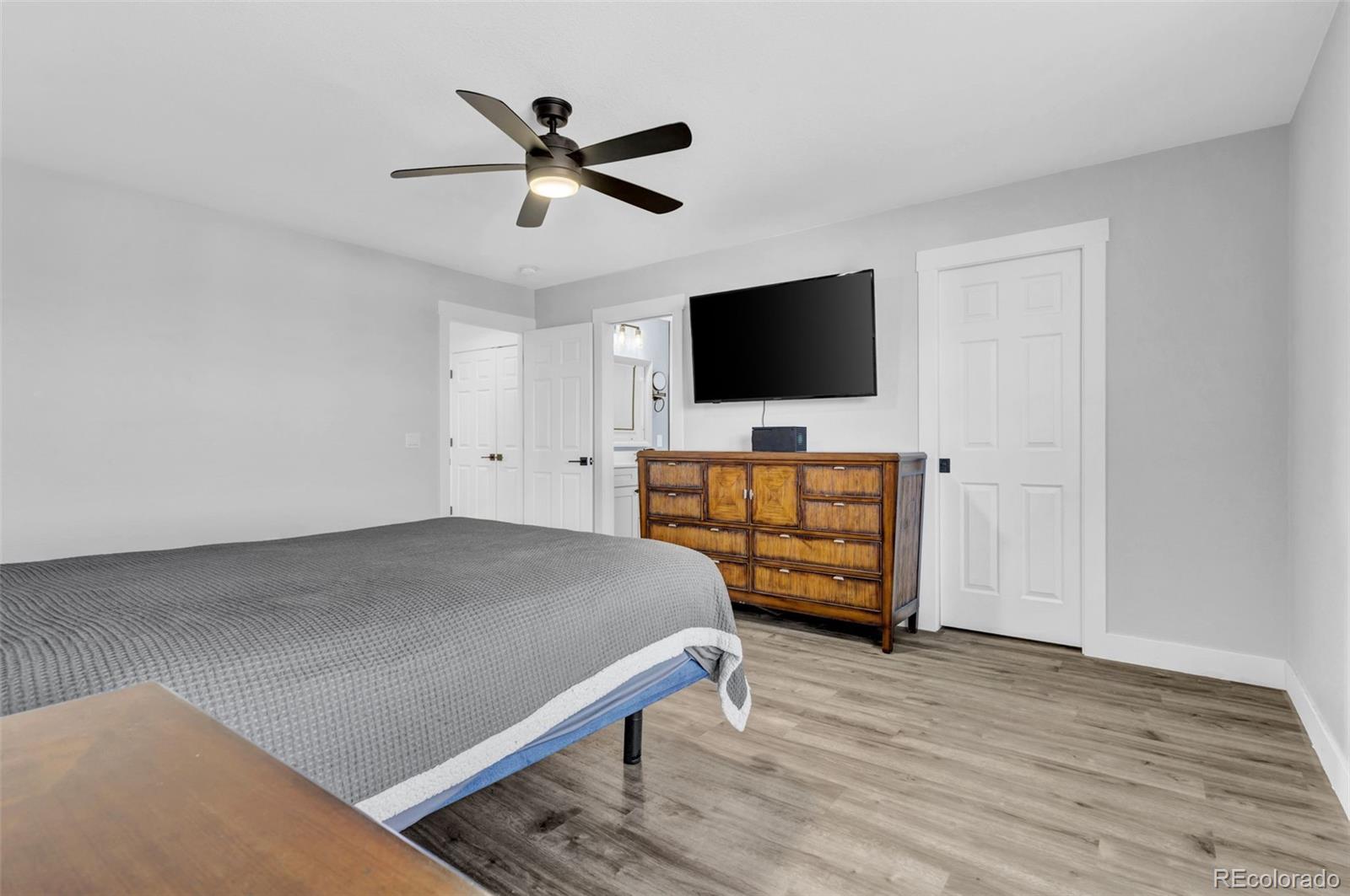 3672 South Perth Circle, Unit 105 Aurora, CO 80013 - Photo 7 of 19 a bedroom with a bed and a flat screen tv