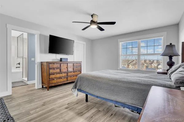 a bedroom with a bed and a flat tv screen on dresser