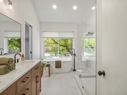 a kitchen with a sink appliances cabinets and a large window