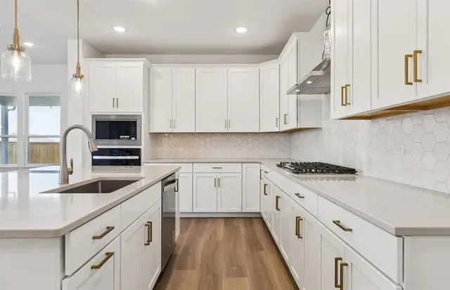 a kitchen with granite countertop white cabinets and white appliances