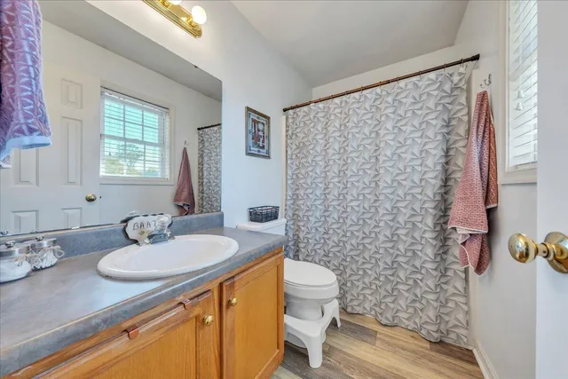 a bathroom with a sink toilet a mirror and shower