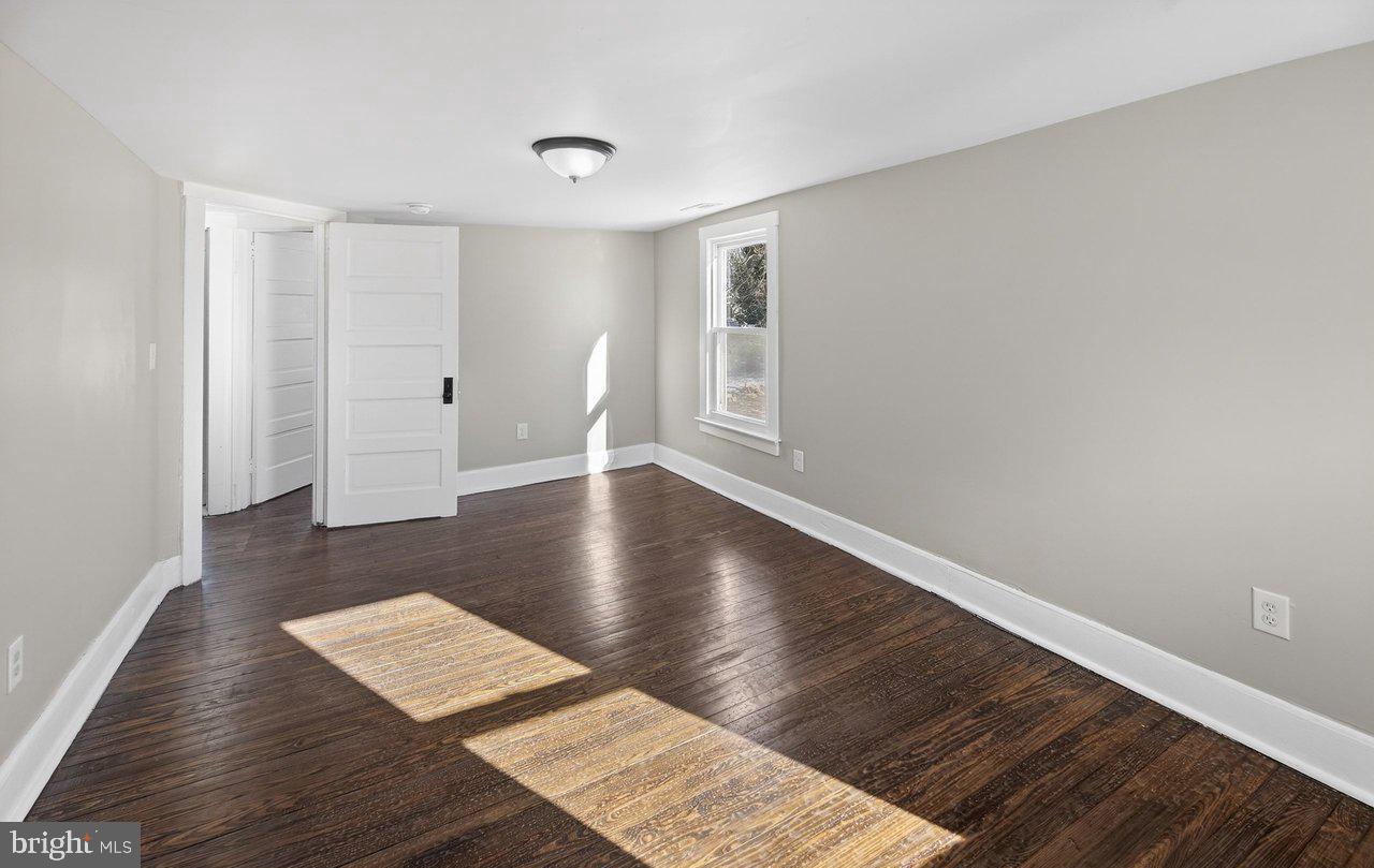 26 Olive Street Salem, NJ 08079 - Photo 17 of 33 a view of an empty room with wooden floor and a window